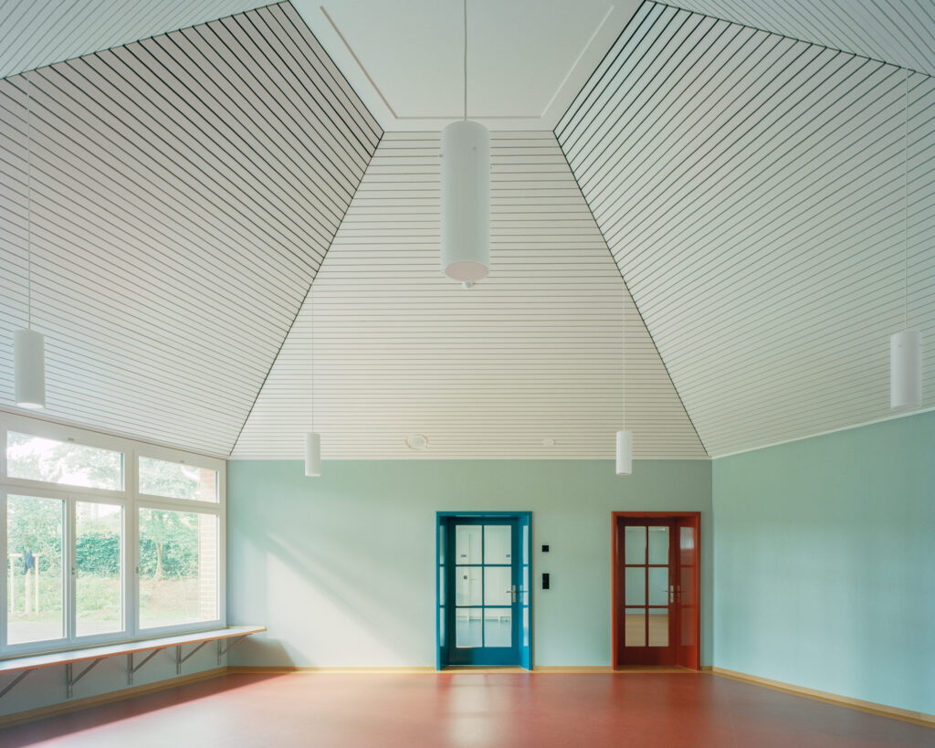 Ein heller Innenraum mit interessanter Deckenkonstruktion, die zu einer Pyramide verläuft.
