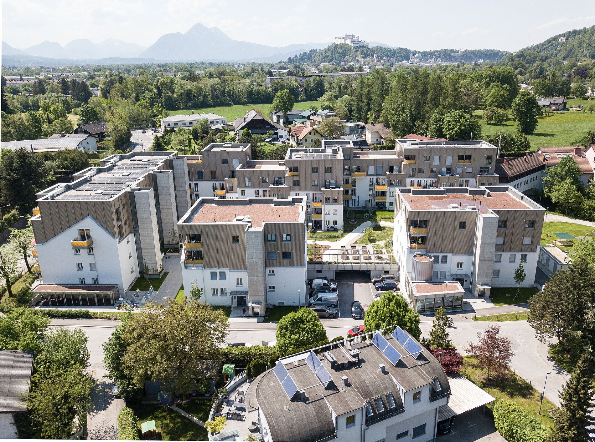 Wohnsiedlung mit modernen Häusern aus Holz, fotografiert von der Luft aus.