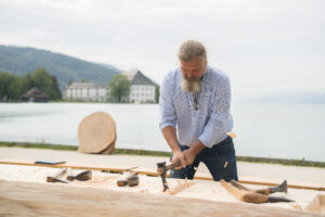 Experimentalarchäologe Wolfgang Lobisser bei der Bearbeitung eines Einbaums.