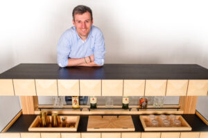 Gerold Hatzmann mit seinem Meisterstück Side Bar, das aktuell auch im Rahmen der Tischlermeistergalerie im Lignorama in Riedau zu sehen ist.