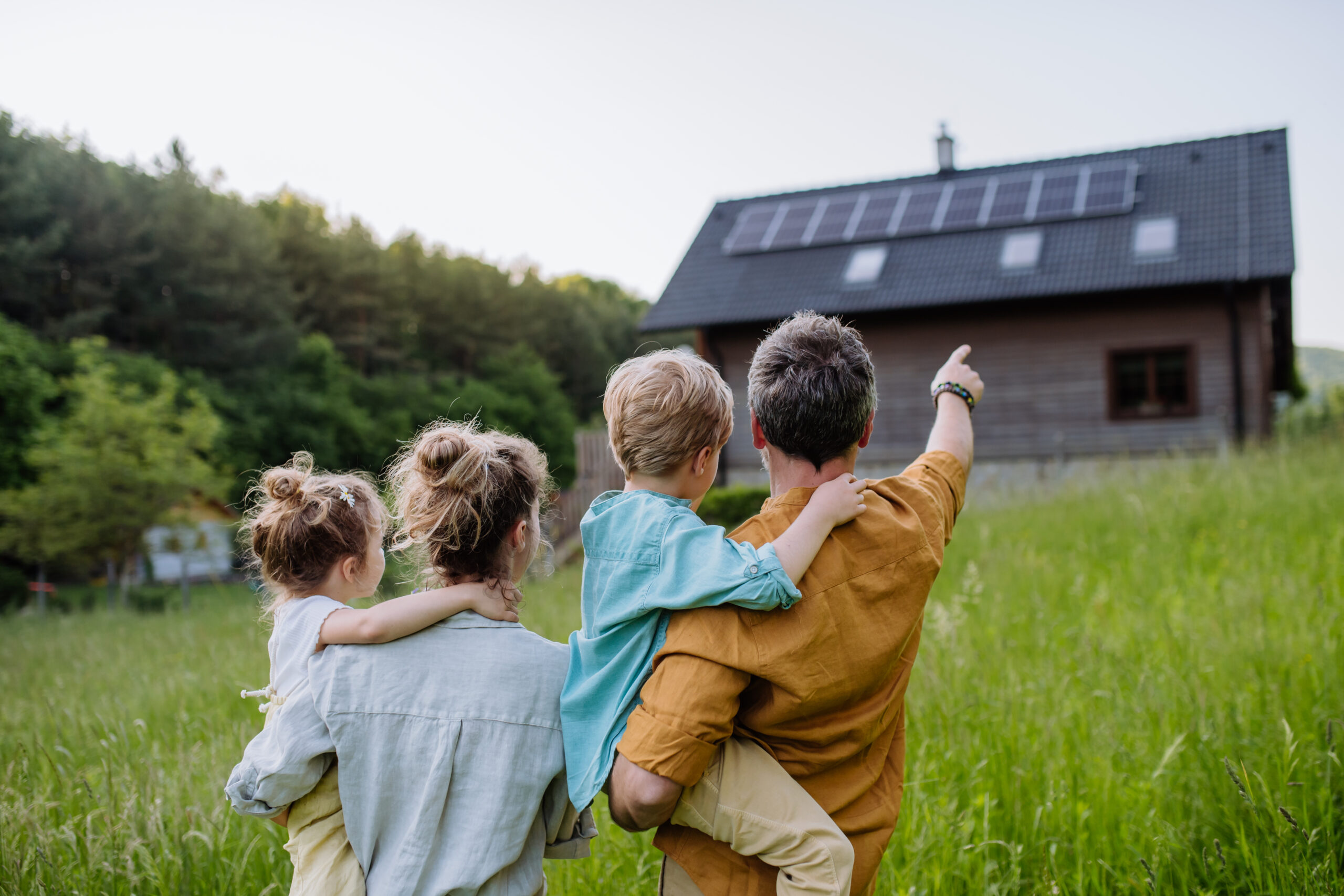Familie zeigt auf Haus. © Halfpoint iStock Getty Images Plus