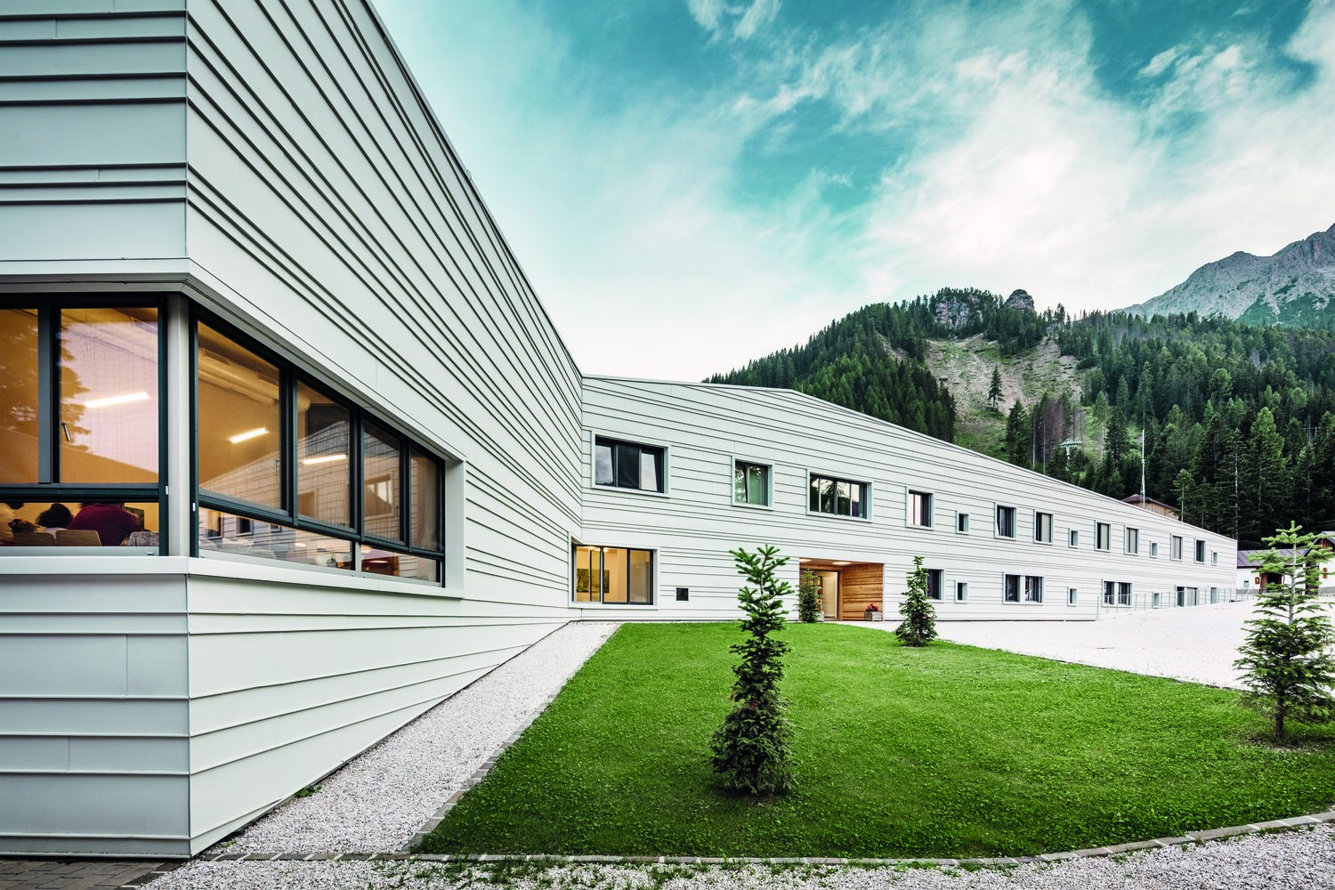 Im alpinen Corvara, in Südtirol, wurde ein Militärgebäude realisiert, das sich deutlich von gewohnten Kasernenbauten abhebt. Die helle Aluminiumhülle wirkt nicht nur klimatisch ausgleichend, sondern prägt auch das moderne Erscheinungsbild der Anlage. © Croce & Wir