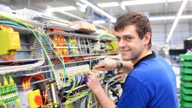 Fachkraft in der Industrie vor Kabelbord