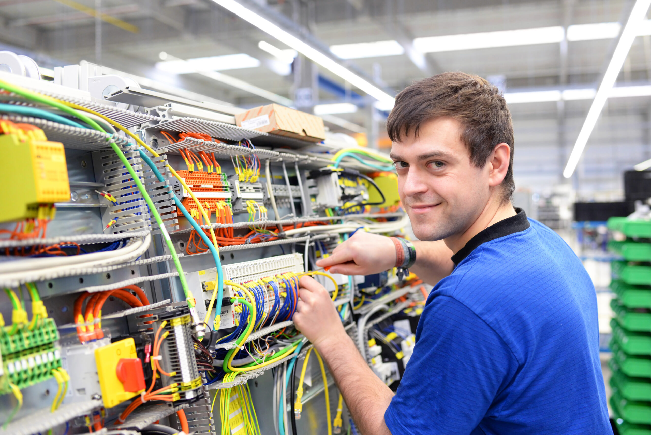 Fachkraft in der Industrie vor Kabelbord
