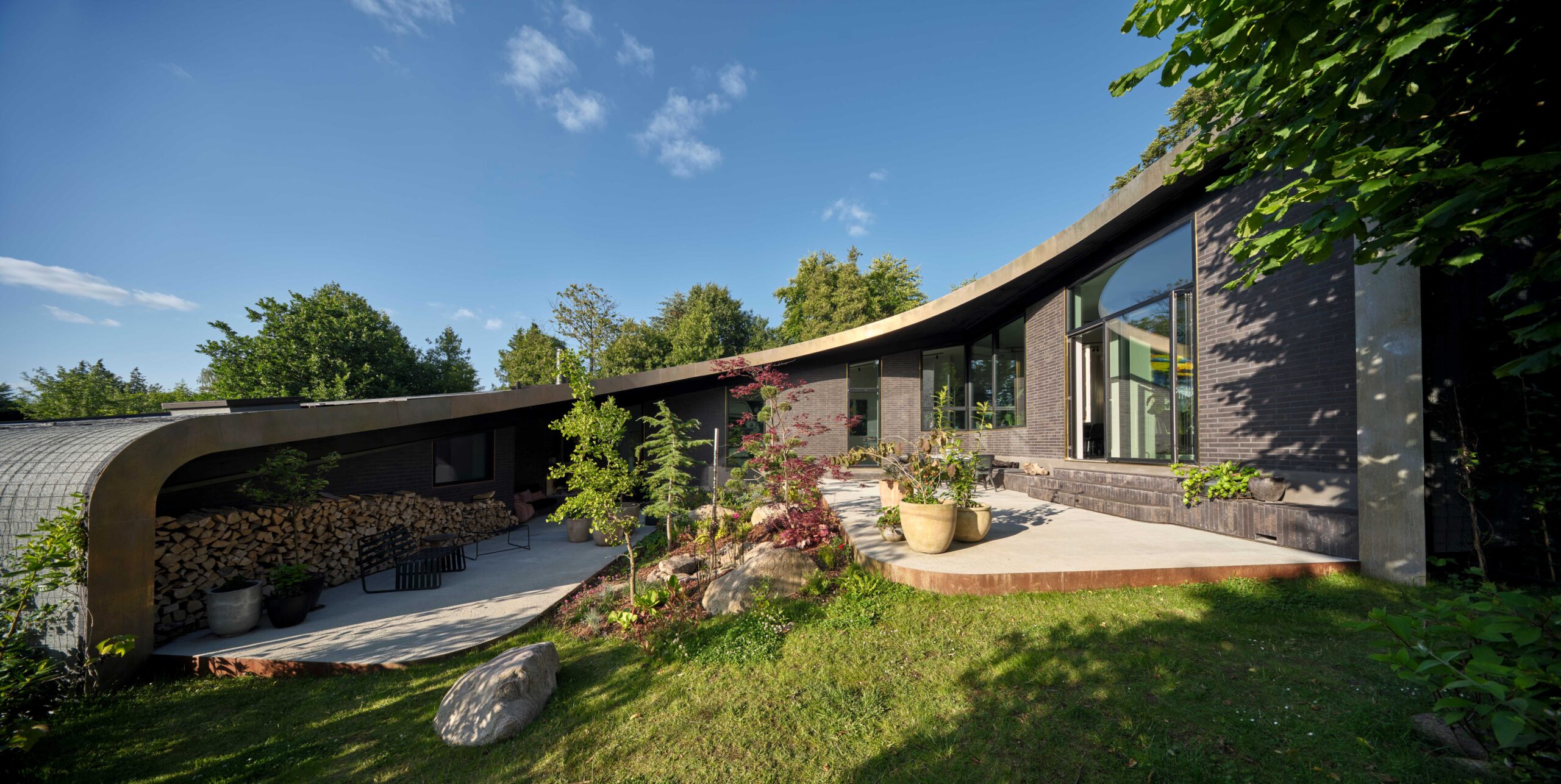 Das ADA House erhebt sich leicht geneigt vom Flügel mit dem Eingangsbereich bis zum Wohn- und Essbereich den Hang hinauf. Von dort und der davorliegenden Terrasse bietet sich ein Ausblick auf die umliegende Landschaft, aber zugleich auch ausreichend Privatsphäre. © Velux / Adam Mørk