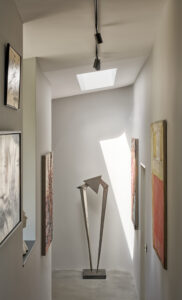 Einfallendes Tageslicht von oben lässt ein faszinierendes Spiel aus Licht und Schatten entstehen, das die ausgestellten Kunstobjekte im Flur stimmungsvoll inszeniert. © Velux / Adam Mørk