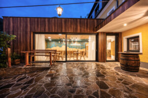 Durch die großzügigen Schiebeglasfronten kündigt ein markanter Blickfang an, was die Gäste im Inneren erwartet: Genuss für alle Sinne! © Obruca Tischlerei & Planung):