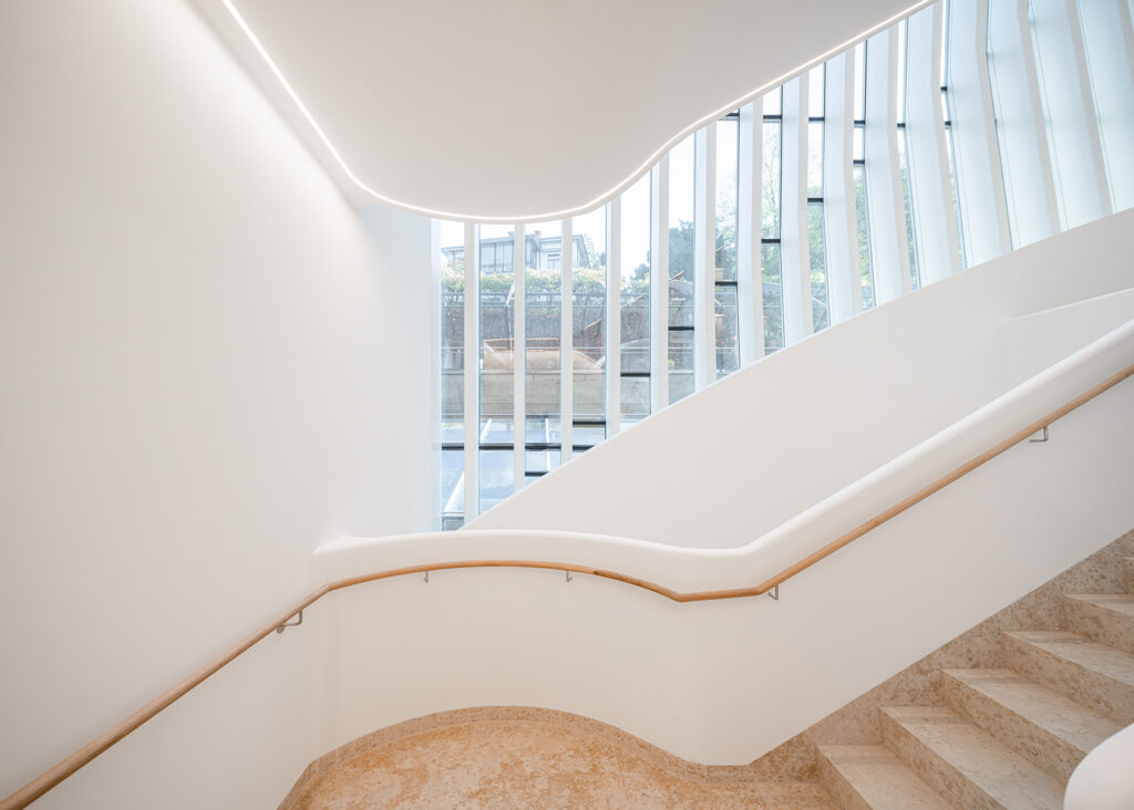 Das viergeschossige Atrium sowie das skulpturale Treppenhaus bilden das räumliche Herz des Gebäudes. © Ingo Rasp