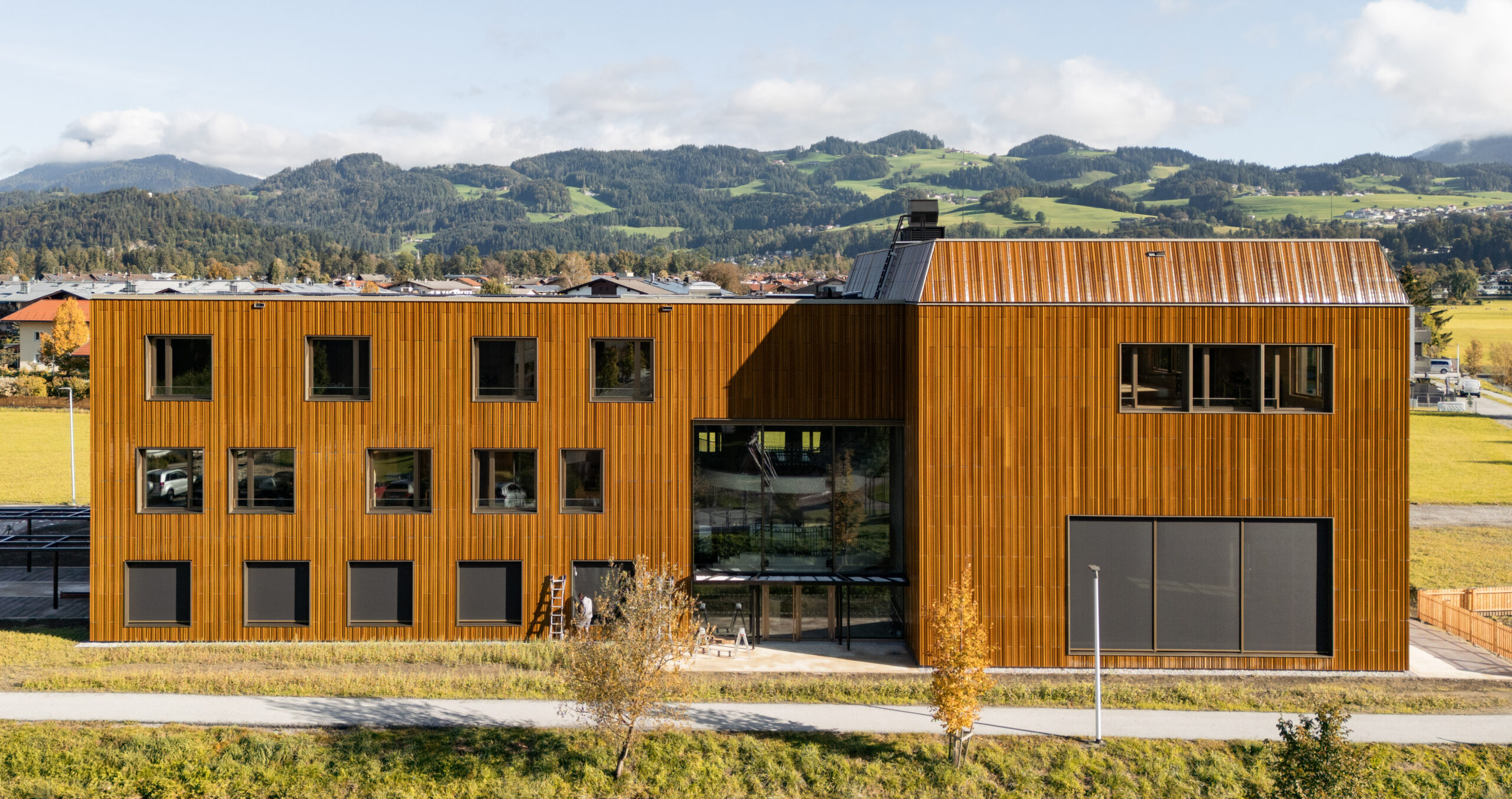 Die neue Landesmusikschule Ebbs gewinnt ihre mar-kante Erscheinung durch eine vorgehängte, hinterlüftete Fassade aus glasierten Keramikelementen. © architekturstil.ch, Dominic Müller