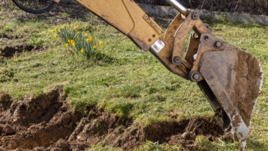An bucket excavator in the village paves the way, digs soil and clears land.