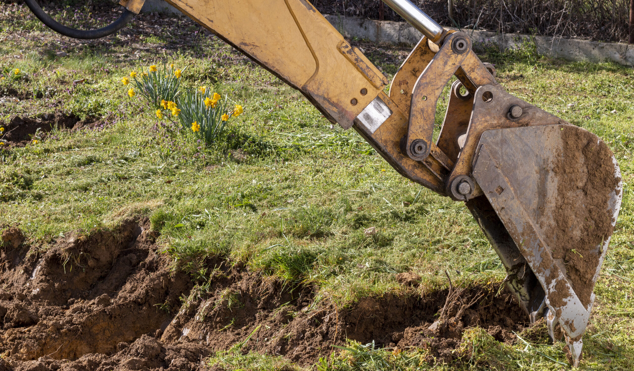 An bucket excavator in the village paves the way, digs soil and clears land.