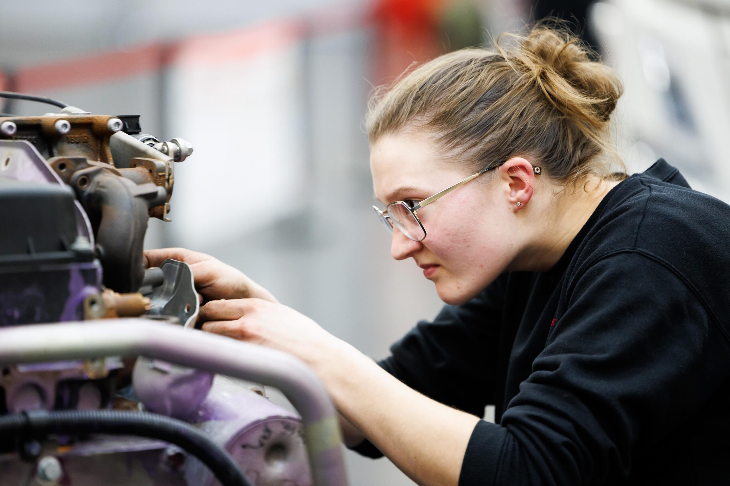 Eine junge Technikerin arbeitet an einer Maschine