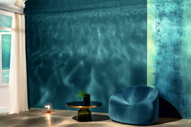 Der warmtonige Holzboden bildet die stabile Basis für das tiefblaue Deep Ocean, das hier von der Spiegeldecke mit und ohne magische Lichtreflektionen aufgenommen wird. Rechts die Oberfläche des Jahres Stucco Eleganza Fusion, bei der Quarzpartikel für eine mineralisch-rau anmutende Haptik und Optik sorgen. © Synthesa