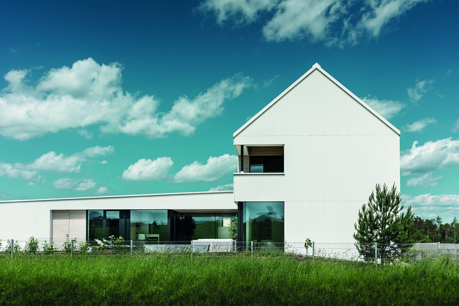 Mit seiner monolithischen Form und der monochrom-weißen Fassade vermittelt das auffällige Haus Purismus in geometrischer Perfektion. © Prefa / Croce & Wir