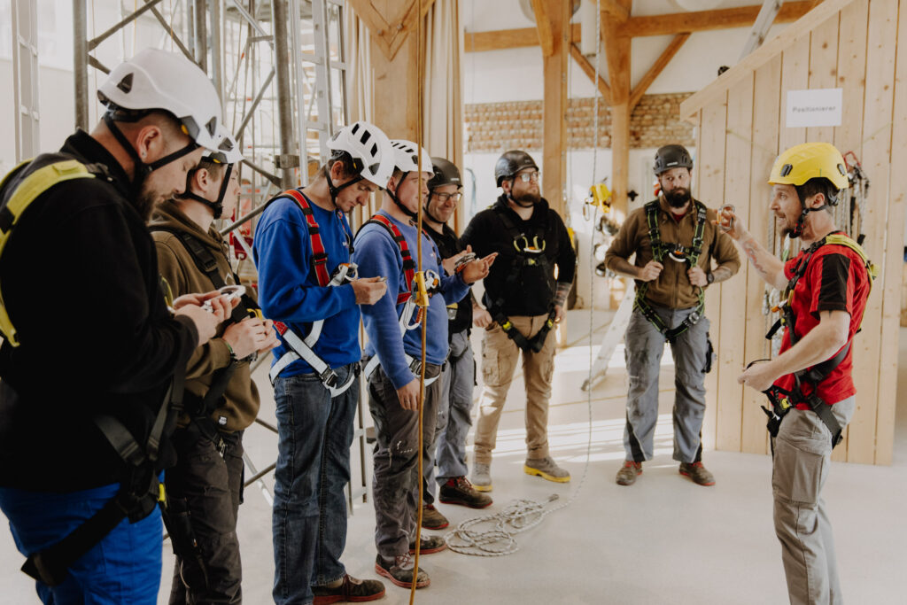 In den Basislehrgängen lernen die Teilnehmer*innen zum Beispiel das richtige Anlegen des Auffanggurts, das sichere Steigen mit dem mitlaufenden Auffanggerät und üben eine einfache Rettung.