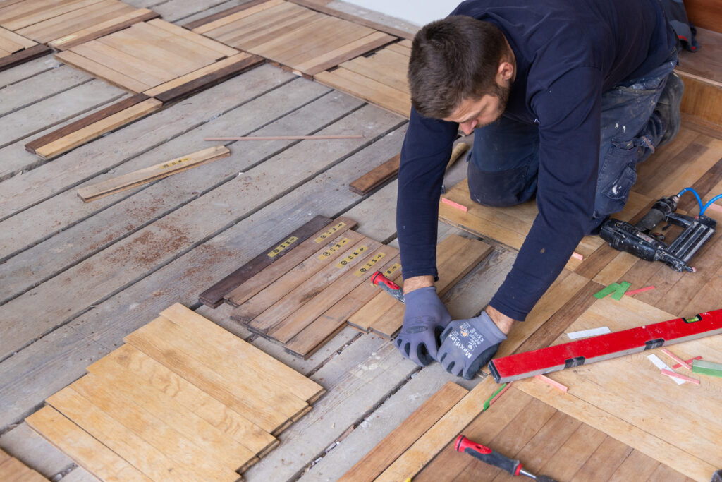 Handwerker restauriert Parkettboden