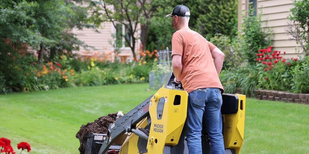Gartenbauarbeiter mit Maschine