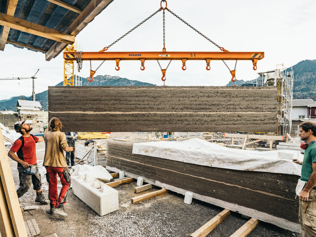 Mit dem Einheben und Montieren der tragfähigen Stampflehmelemente sind gleichermaßen die Außen- und Innenwandoberflächen nahezu fertiggestellt.