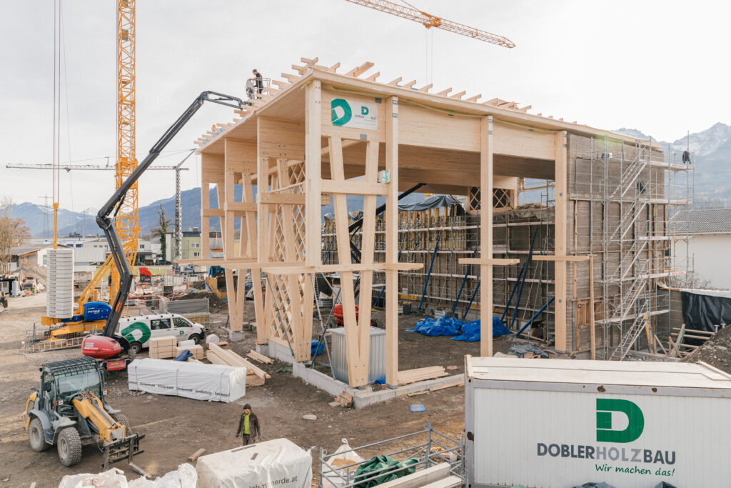 Montage der Brettschichtholz-Konstruktion mit großdimensionalen Leimbinder-Trägern und V-förmigen Stützen.