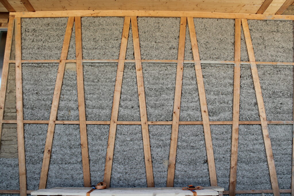 Die BS-Rahmenkonstruktion wurde mit einer selbst angesetzten Hackschnitzel-Lehm-Mischung lokalen Ursprungs gedämmt.