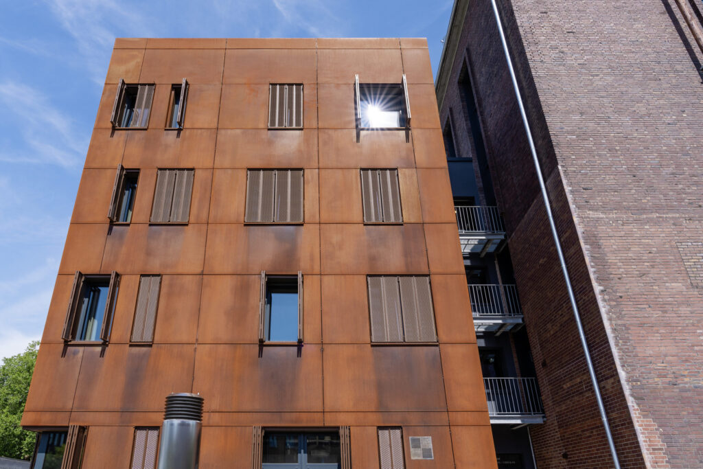 Fassade aus Cortenstahl mit Streckmetall-Faltschiebeläden.