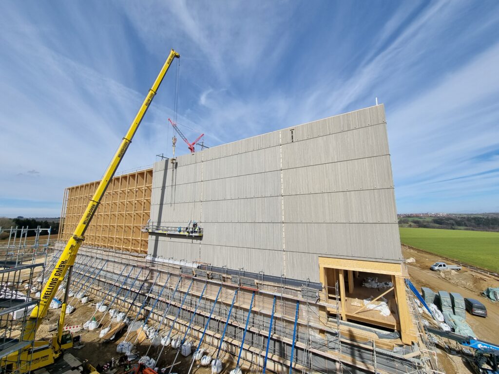 Die Gebäudehülle oberhalb der Stampflehmebene besteht aus sechs aufeinander gestellten Holzrahmenbau-Elementreihen.