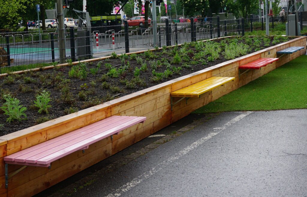 Hübsche Sitzbänke in Pink, Gelb, Rot, Blau und Grün laden zu einer Rast ein.