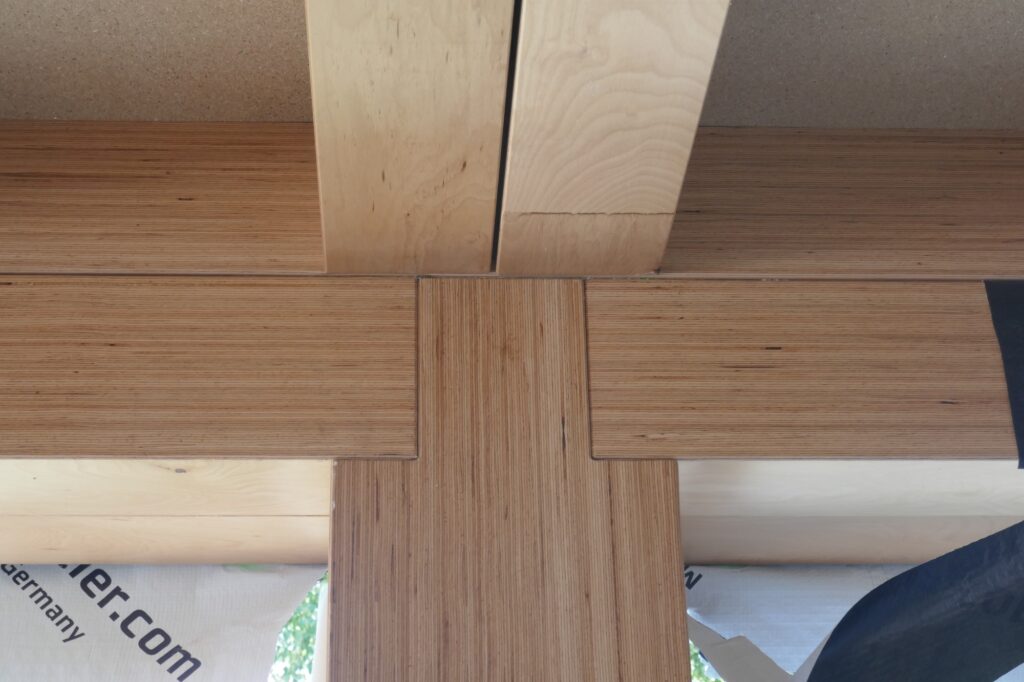 Stützen, Träger und Rippendecken fügen sich wie ein dreidimensionales Puzzle formschön ineinander. Die Holz-Holz-Verbindungen fungieren als Druckanschlüsse und ermöglichen die Lastdurchleitung über den direkten Kontakt von Holz auf Holz.