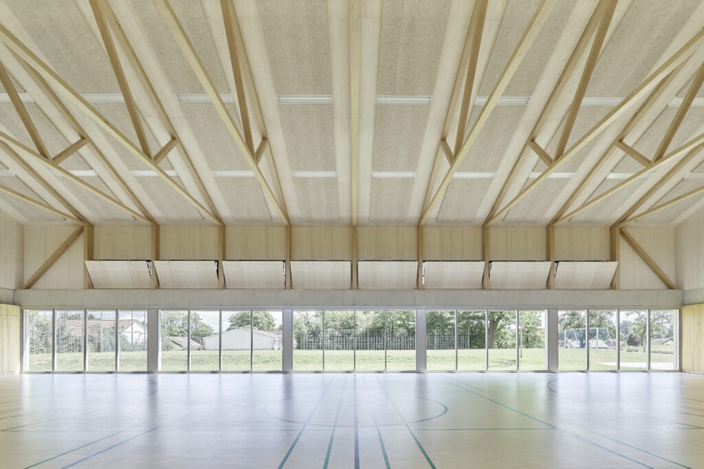 In der Längsansicht gut zu erkennen: Das Achsraster der Stahlbetonstützen ist doppelt so groß, wie das der Polonceau-Träger. Akustikelemente aus Holzwolle-Leichtbauplatten ließen sich auf der Dachunterseite gut zwischen den Trägern einfügen.