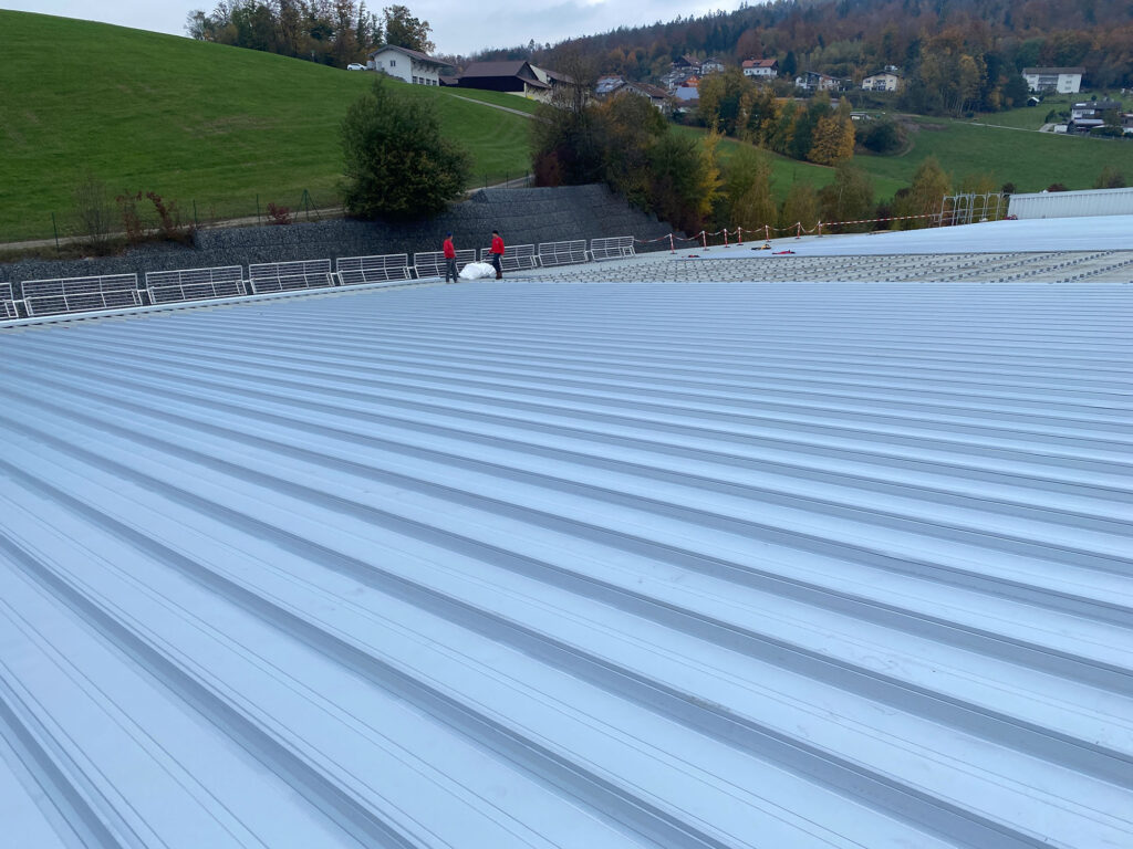 Die Profilbahnen aus Stahl mit Aluzink-Oberfläche werden systemgerecht verlegt und bilden die neue regensichere Dachfläche.