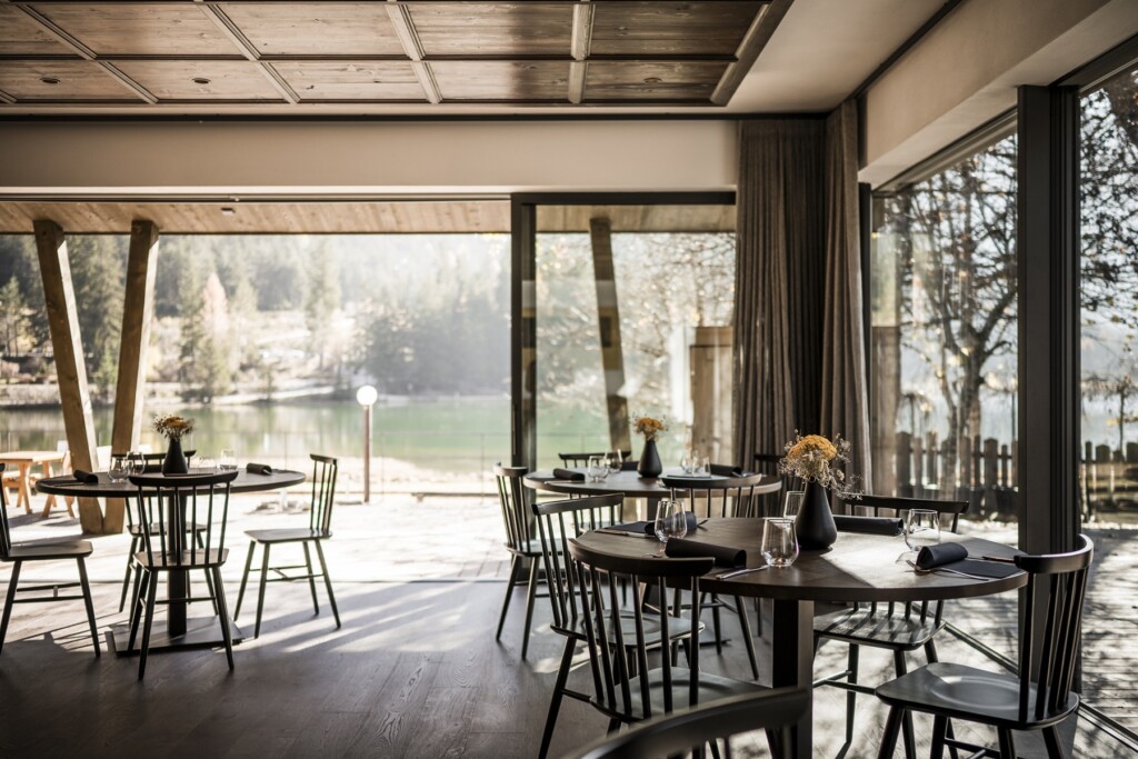 Die Verglasungen holen See, Wald und Bergpanorama optisch in den Innenraum und machen die Landschaft zum Teil des Restauranterlebnisses.